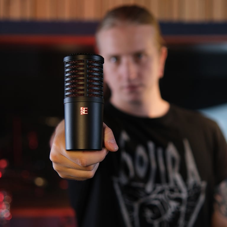 Drummer, Maxim Moskovkin holding the bottom of the DynaCaster straight towards the camera showing the sE logo.