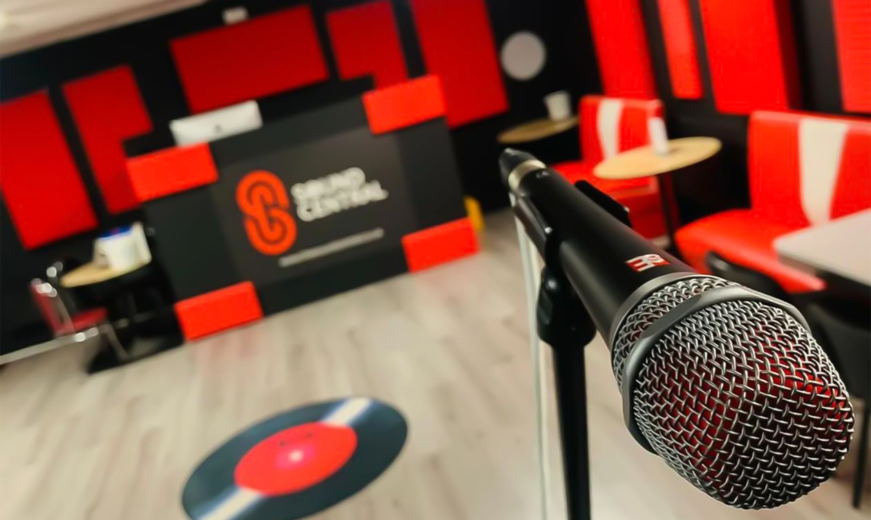 A V7 microphone in a recording studio lobby with black walls and red sound treatment.